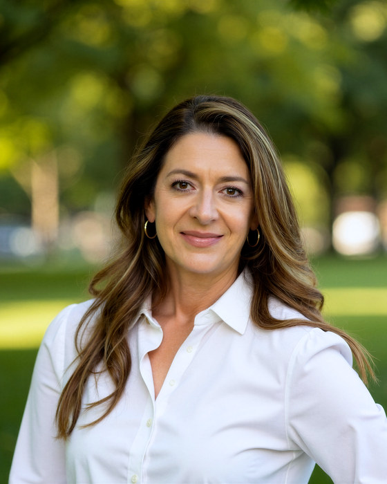 Arcelia Emerson, MA, LPC Associate, outdoors under trees in a white collared shirt.